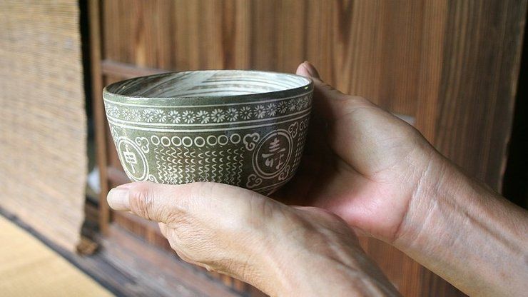 Offering tea in a Japanese tea bowl