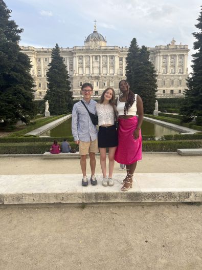 Interns pose for a photo in front of a Spanish palace.