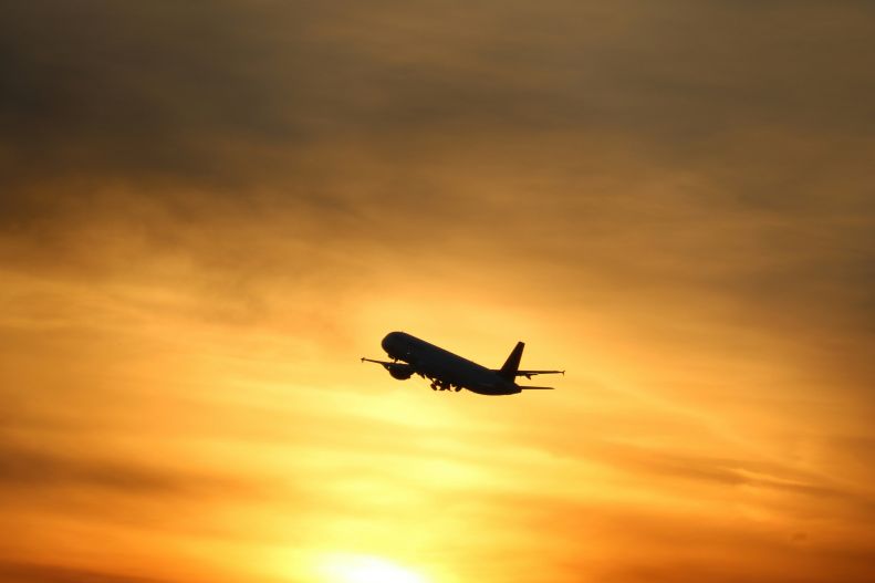 plane flying at sunset