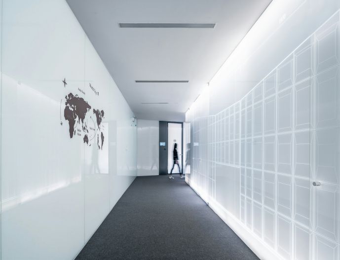 Person walking in a hallway with a map on the wall