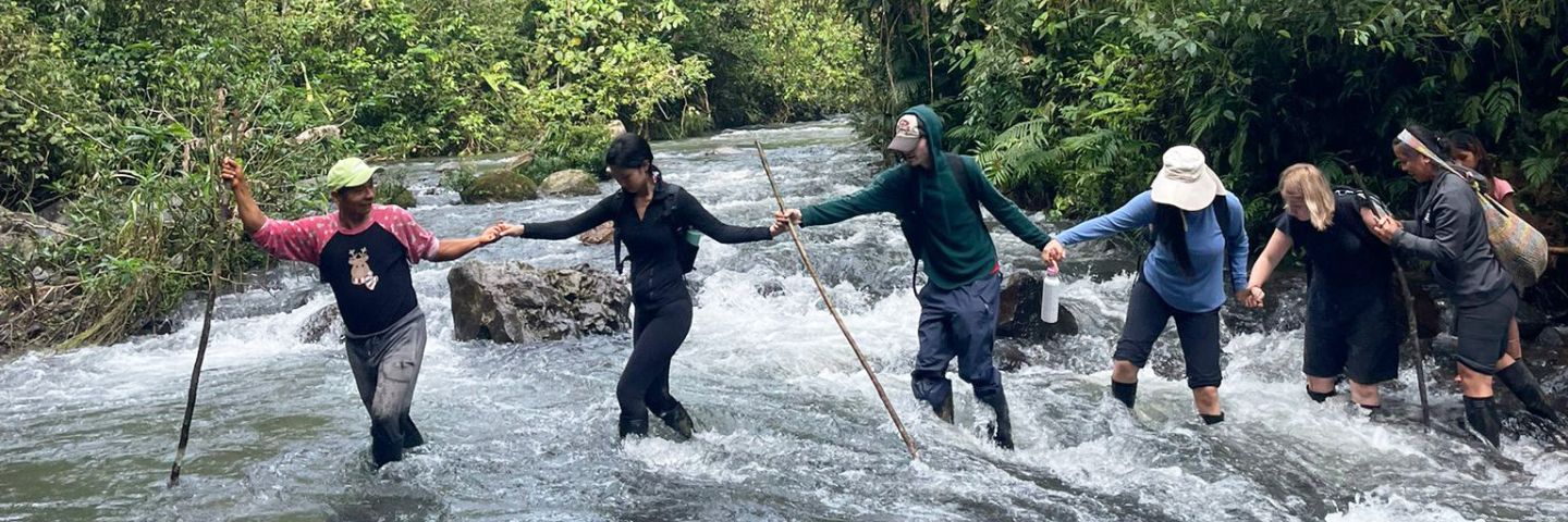Group of people crossing river