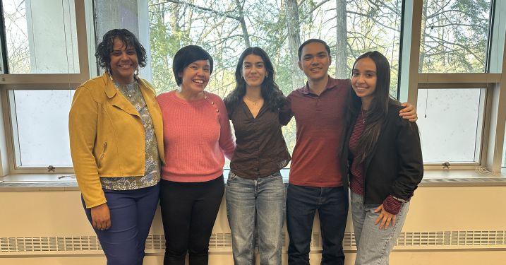 Scholars stand with event speakers.