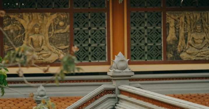 The roof of a temple, with Buddhist motifs visible in the background. 