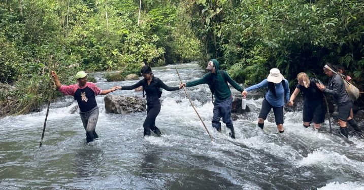 Group of people crossing river