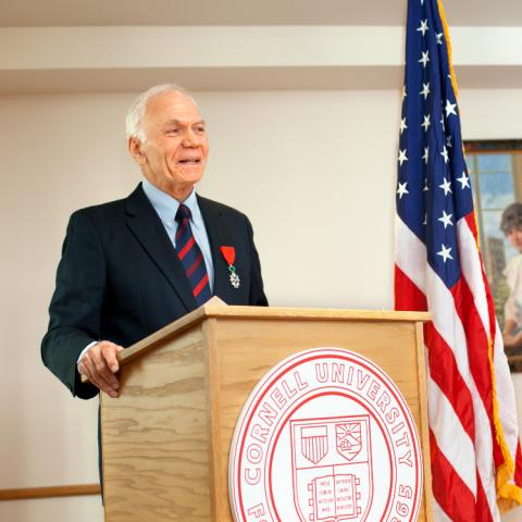 John Barcelo standing behind podium