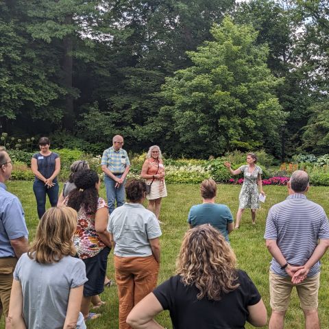 Teachers stand around outside before an activity. 