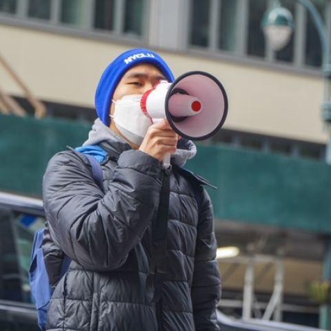 Jonathan Lam speaks into a megaphone. 