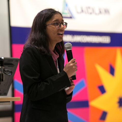 Trisha Bhujle speaks into a microphone. 