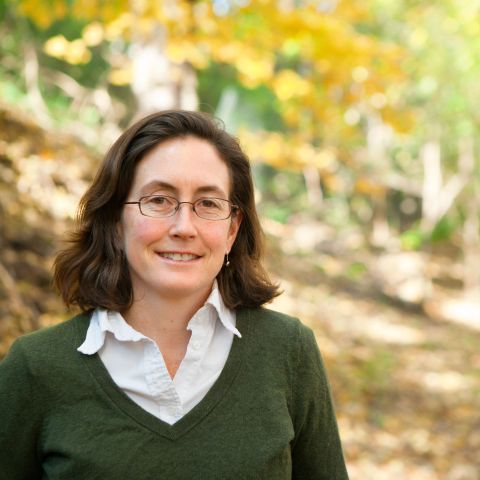 Natalie Mahowald posing outside in front of a yellow tree.