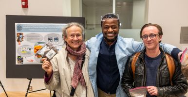Laidlaw scholars and their faculty mentor smile together in front of a research poster.